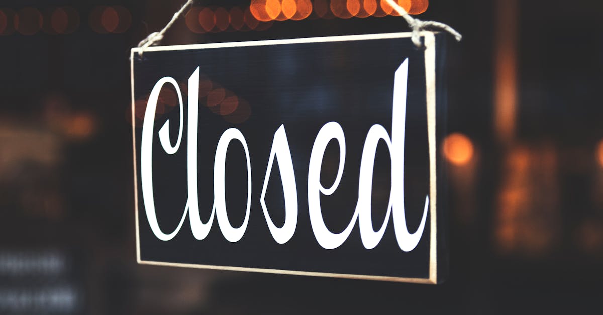 A close-up of a 'Closed' sign hanging against a blurred, bokeh background, creating a warm, inviting atmosphere.